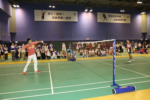 內地奧運選手諶龍（左）與英皇佐治五世學校的學生對打羽毛球。