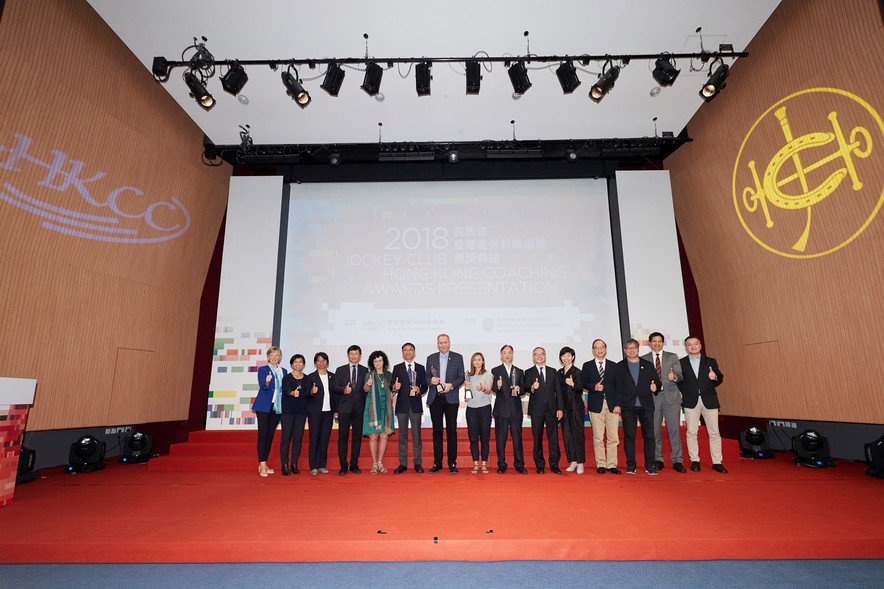 The officiating guests Mr Lau Kong-wah JP, Secretary for Home Affairs (6<sup>th</sup> from right); Miss Donna Tang, Executive Manager, Charities (Grant Making – Sports and Environment) of The Hong Kong Jockey Club (5<sup>th</sup> from right); and Ms Vivien Lau BBS JP, Chairman of the Hong Kong Coaching Committee (5<sup>th</sup> from left) congratulated the Coach of the Year awardees including Kwok Hart-wing (7<sup>th</sup> from right), Chiu Wing-yin (8<sup>th</sup> from right), Octavian Zidaru (7<sup>th</sup> from left), and Lo Wan-kei (6<sup>th</sup> from left). They took a group photo with other guests on stage.